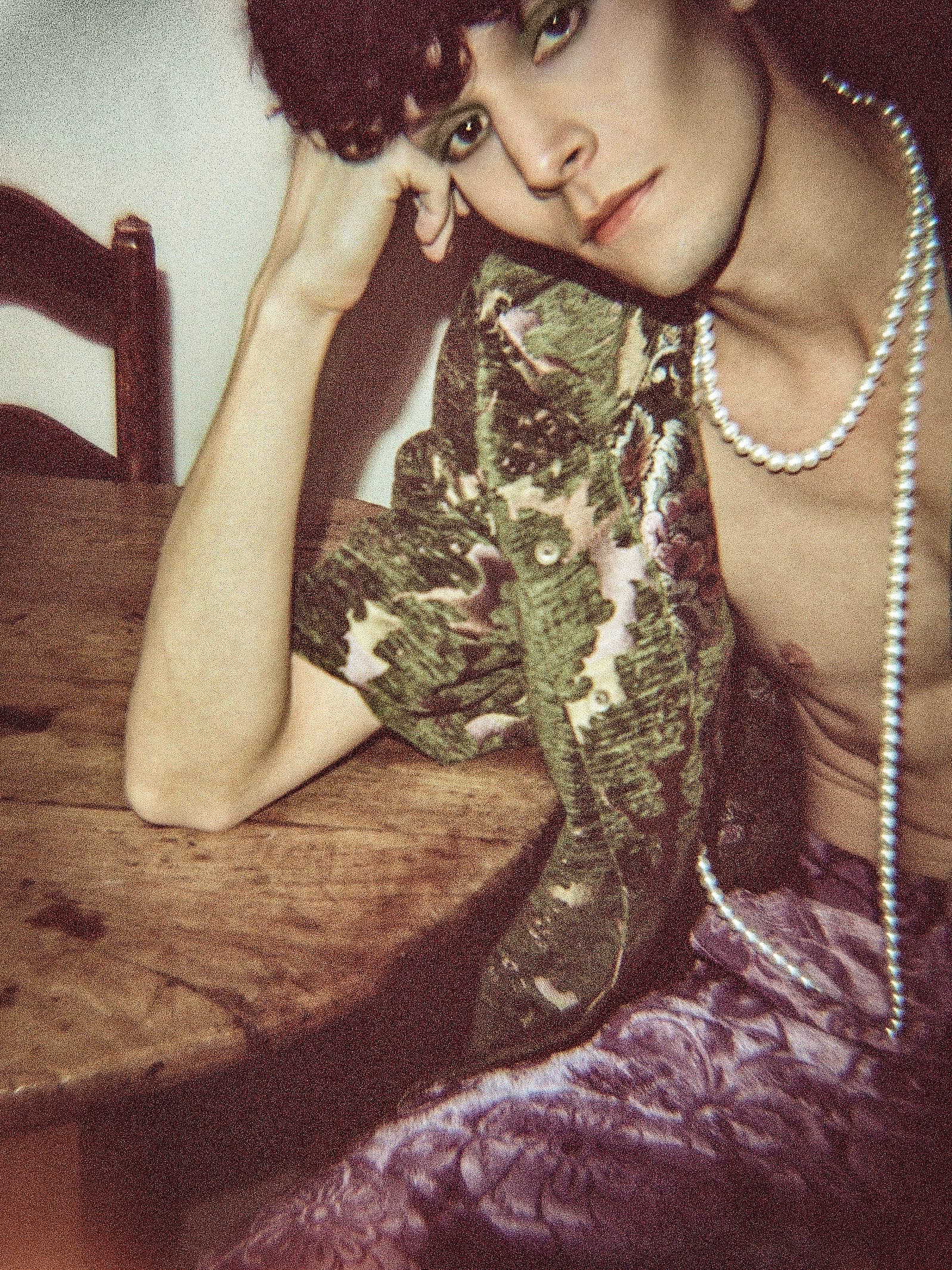 Soft-focus portrait leaning on a wooden table